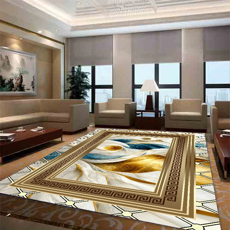 Un tapis à motif géométrique doré et bleu dans un salon élégant avec des fauteuils en cuir beige.