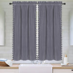 Deux panneaux de rideaux gris en velours avec finitions pompons installés dans une salle de bain au style moderne et épuré.
