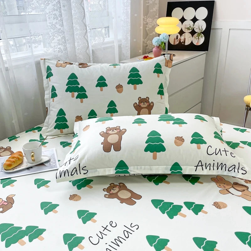 Literie conçue avec des motifs mignons d'animaux des bois tels que des ours et des écureuils entourés de conifères verts sur un fond blanc.