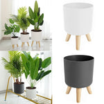 Pot de fleur sur pied en bois et plastique blanc dans un salon moderne