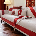 Un canapé élégant avec des éléments décoratifs rouges et gris, créant une ambiance chaleureuse et sophistiquée.