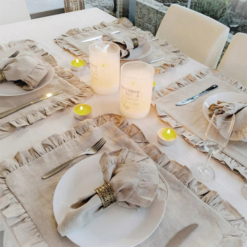 Une table dressée avec élégance, des serviettes en tissu, des bougies chaleureuses et des détails dorés créent une ambiance conviviale et raffinée.