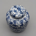 Vase décoratif en porcelaine blanche et bleu, présentant un motif floral délicat et élégant.