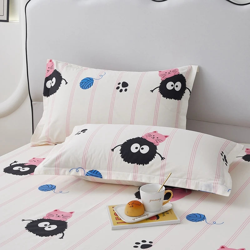 Ensemble de literie avec imprimé de créatures peluches noires et roses sur un fond blanc à rayures roses délicates.