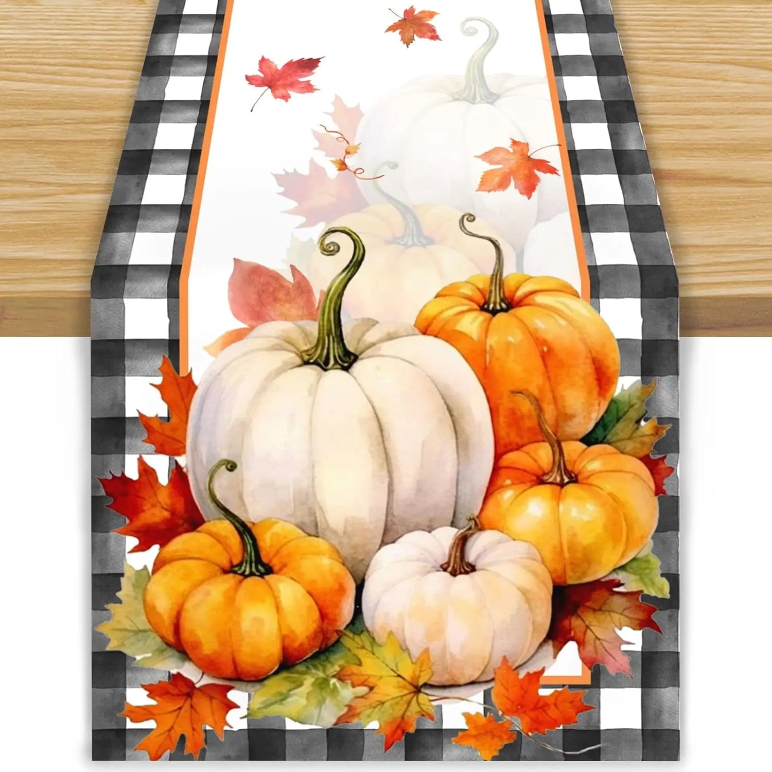 Arrangement automnal avec de beaux citrouilles blanches et orange sur un fond de motif à carreaux noirs et blancs.