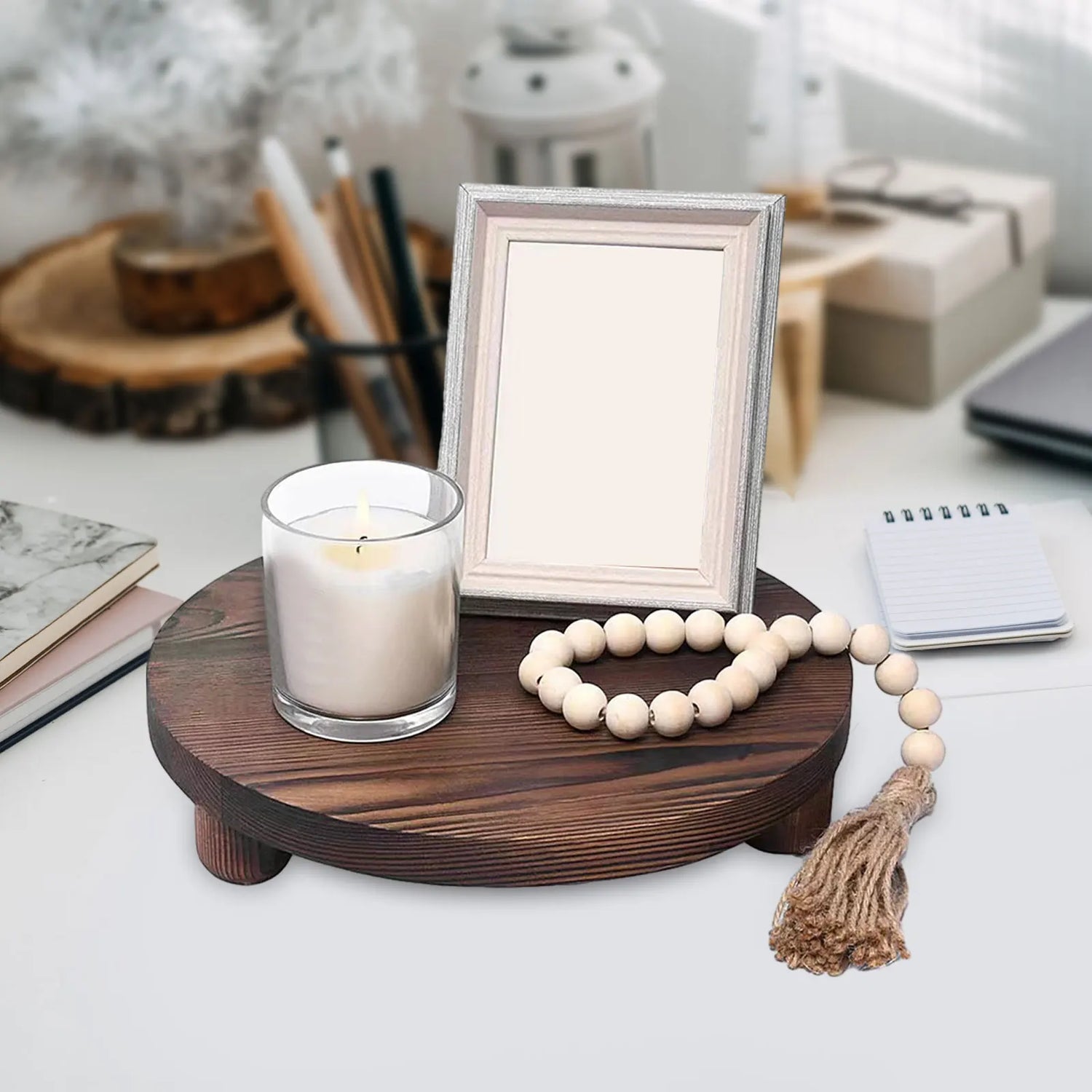 Plateau sur pied en bois brut rond blanc avec des plantes succulentes et des bougies