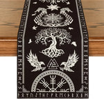 Cette bannière décorative noire et blanche présente un design complexe et symbolique, avec des éléments mystiques comme un arbre de vie, des oiseaux et des runes nordiques. Il s'agit d'une oeuvre d'art intrigante et mystérieuse qui évoque des traditions spirituelles.