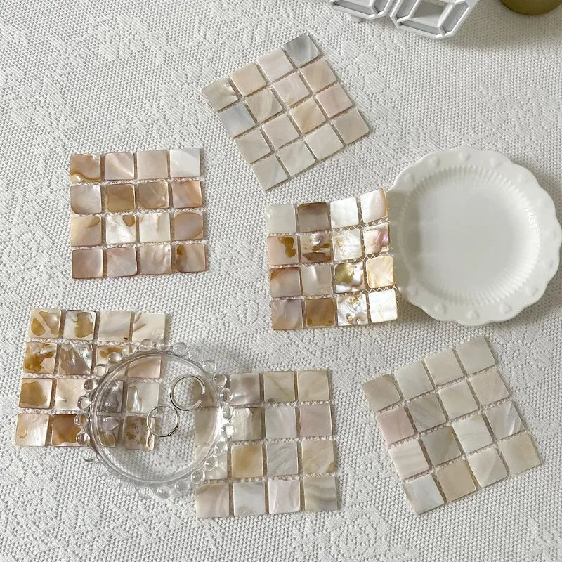Ensemble de sous-verres en coquille de conque de différentes couleurs disposés en mosaïque