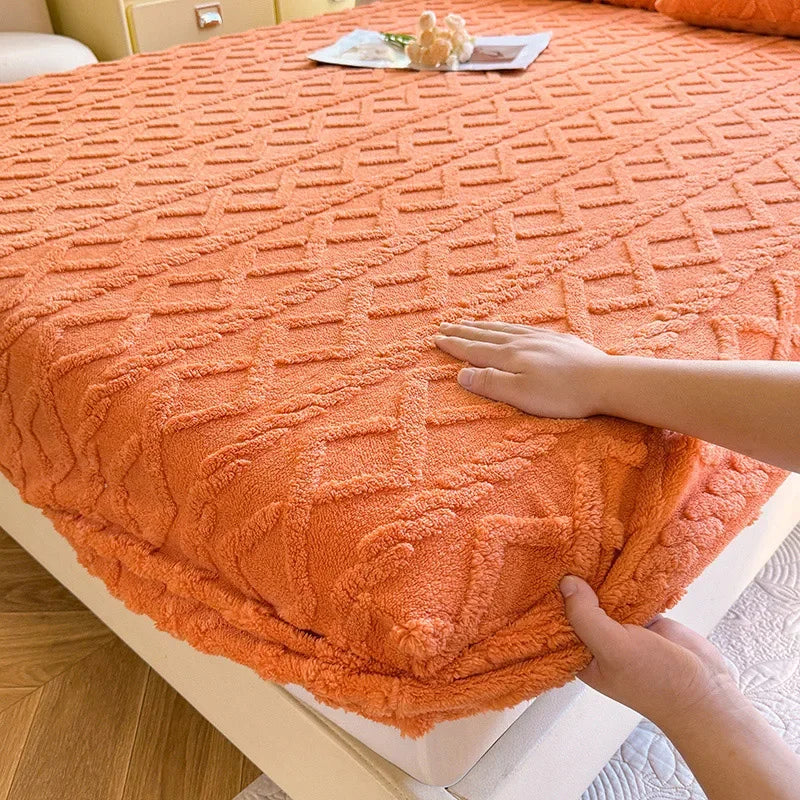 Une couverture de lit orange chaude et moelleuse avec un motif géométrique en relief.