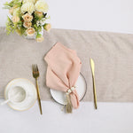 Une table élégante avec un bouquet de fleurs blanches et roses, une assiette et des couverts dorés, et une serviette de table rose nouée avec une décoration.