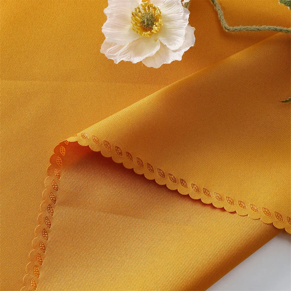 Une fleur blanche avec des bords dentelés se détache sur un fond jaune vif et texturé.