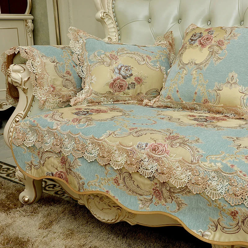 Un somptueux ensemble de literie avec motifs floraux et dentelle délicate sur un fond bleu clair, créant une atmosphère élégante et romantique dans la chambre.