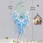 Dreamcatcher décoratif en plumes bleu ciel, lune et flocon de neige avec ornements lumineux.