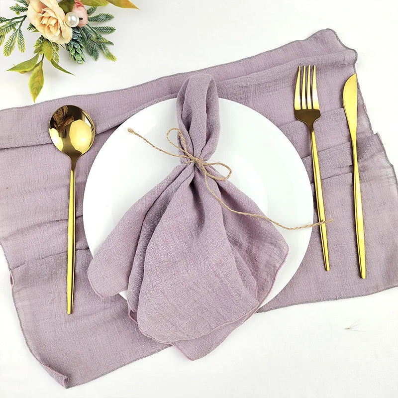 Une table élégante avec des couverts dorés, un napperon gris et une décoration florale apportant une touche de luxe et de raffinement à ce décor de table.