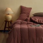 Couette gris foncé avec des coussins décoratifs assortis