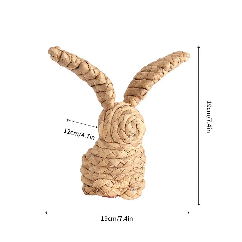 Un lapin décoratif tressé en matière naturelle, avec des dimensions d'environ 19 cm de largeur sur 19 cm de hauteur.