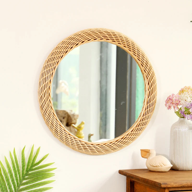 Miroir mural rond en rotin tissé main de couleur bronze sur un mur blanc