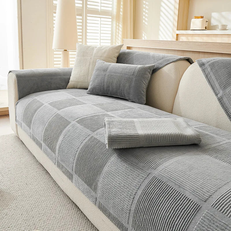 Le canapé gris et crème avec des motifs géométriques offre une atmosphère confortable et élégante dans cette pièce ensoleillée.