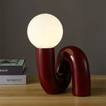 Lampe de chevet rouge posée sur une table de nuit