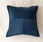 Un coussin en velours côtelé bleu marine avec un motif de lignes verticales formant un design élégant et graphique.