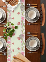 Ensemble de table élégant avec vaisselle blanche, couverts en bois et décoration florale sur un fond de bois foncé.