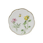 Une assiette décorative en porcelaine blanche ornée de fleurs et de feuillage colorés.