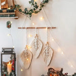 Décoration murale bohème chic avec suspensions en forme de feuilles, ornée de petites perles en bois. Cette pièce artistique ajoute une touche élégante et naturelle à n'importe quel intérieur. Parfaite pour sublimer un salon ou une chambre, elle est agrémentée par des guirlandes lumineuses créant une ambiance chaleureuse. Accessoire idéal pour une décoration intérieure tendance et apaisante.