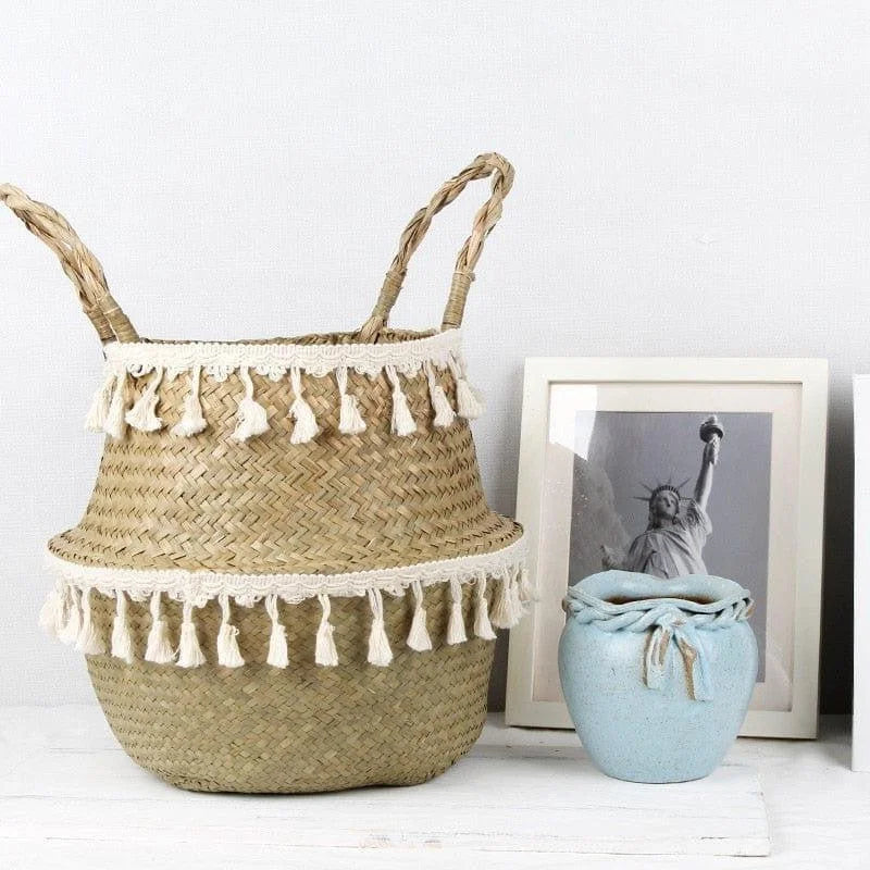 Panier décoratif avec franges blanches, idéal pour rehausser l'esthétique d'un intérieur moderne. Ce panier au design élégant est parfait pour organiser des espaces de vie tout en ajoutant une touche bohème. Placé à côté d'un vase bleu et d'un cadre photo, il s'intègre parfaitement dans un décor minimaliste, offrant à la fois utilité et style.