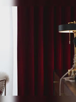 Vidéo montrant un rideau occultant bordeaux en velours dans un salon chic avec lampe dorée, ambiance feutrée et tamisée.