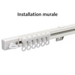 Rail de rideau blanc monté au mur avec crochets glissants, parfait pour suspendre des rideaux avec élégance et stabilité.