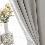 Rideau élégant de couleur grise, idéal pour sublimer votre décoration d'intérieur moderne. Parfait pour ajouter une touche de sophistication à votre salon ou chambre à coucher. Accompagné d'un vase décoratif avec des plantes artificielles pour un style raffiné et contemporain.