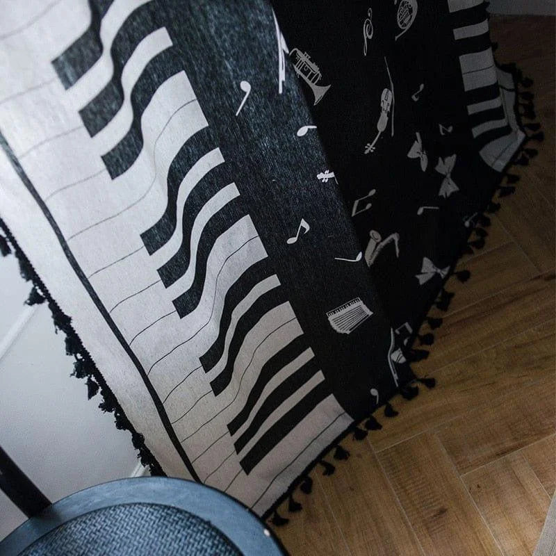 Plaid design piano noir et blanc avec motifs musicaux pour déco intérieure moderne. Accessoire idéal pour les amateurs de musique souhaitant ajouter une touche artistique à leur salon ou chambre à coucher. Adapté pour créer une ambiance élégante et chaleureuse.