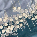 Broderie élégante avec motifs circulaires sur fond bleu, idéale pour personnaliser des vêtements ou accessoires. Design raffiné et moderne avec paillettes blanches ajoutant une touche de glamour. Convient pour création de tenues sophistiquées et uniques. Parfait pour la haute couture et la décoration textile.