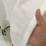 Voile blanc semi-transparent avec bordure décorative en pompons jaunes et bleus, idéal pour ajouter une touche élégante à votre décoration intérieure. Parfait pour les rideaux ou autres projets créatifs dans votre maison.