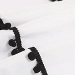 Rideau blanc avec détail de bordure à pompons noirs, design élégant et moderne pour ajouter une touche unique à votre décoration intérieure. Idéal pour les salons, chambres, et espaces de vie, ce rideau offre un style distinctif et sophistiqué.
