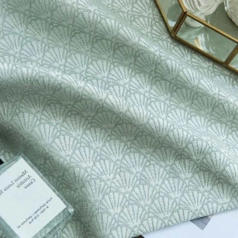 Tissu élégant avec motif géométrique inspiré de coquillages, idéal pour la décoration intérieure. Ce design subtil et raffiné apporte une touche contemporaine à tout espace, parfait pour confectionner des rideaux ou des coussins. Harmonie des couleurs douces, idéale pour un intérieur moderne et apaisant.