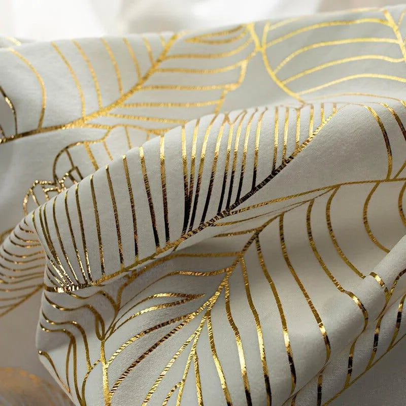 Image d'un tissu orné de motifs dorés élégants, évoquant des designs luxuriants et modernes. Idéal pour la décoration intérieure glamour et les projets de design sophistiqués. Ce textile ajoutera une touche chic à tout espace.