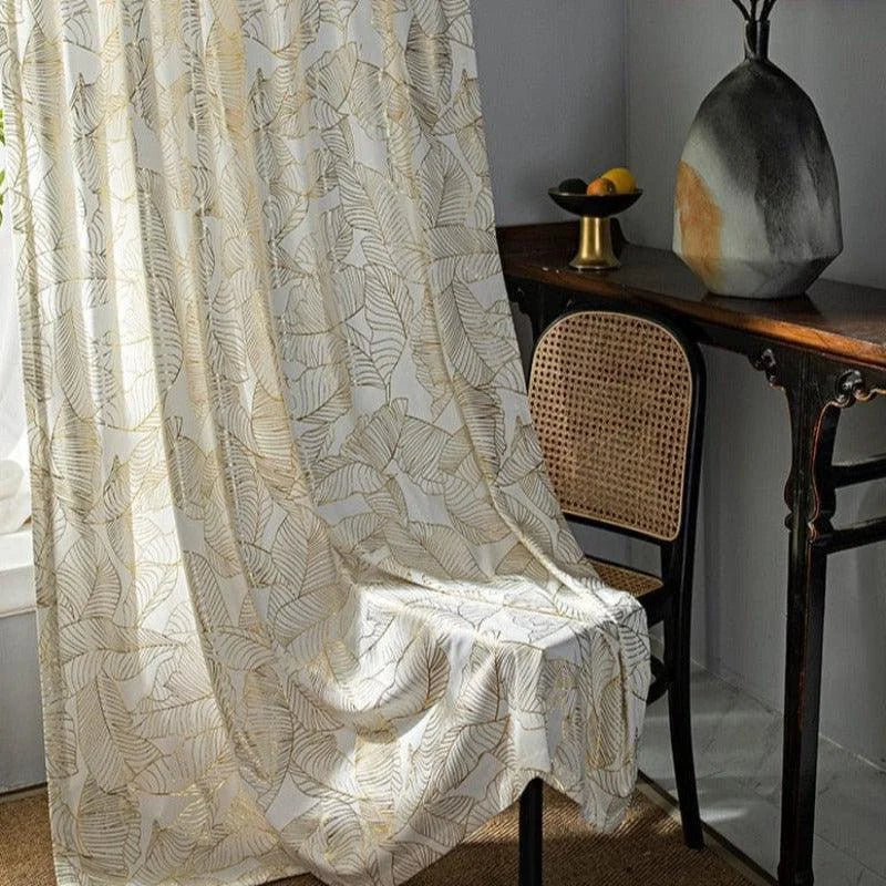 Rideau élégant avec imprimé végétal doré, idéal pour sublimer la décoration intérieure. Ce modèle apporte une touche raffinée à votre salon grâce à son motif délicat inspiré de la nature. Parfait pour créer une ambiance chaleureuse et accueillante, il convient à tout type de pièce et style de mobilier.
