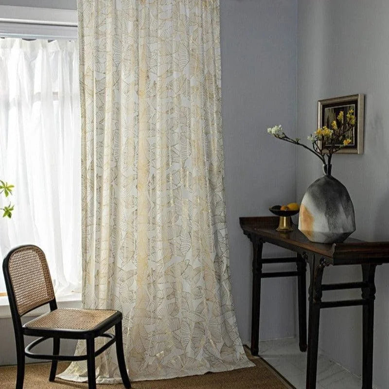 Rideau élégant à motifs géométriques et floraux dans une pièce lumineuse, idéal pour ajouter une touche de sophistication à la décoration intérieure. Disposez ce rideau près d'une fenêtre pour tamiser la lumière tout en créant une ambiance chaleureuse. Parfait pour un salon ou une chambre, ce rideau rehausse le style de votre espace avec subtilité et modernité.