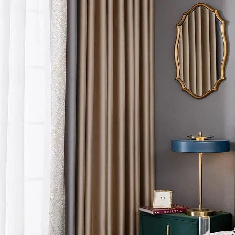 Rideau élégant couleur taupe pour salon moderne, accompagné d'un miroir doré au mur et d'une lampe de chevet bleue, parfaite pour une décoration intérieure raffinée et contemporaine. Idéal pour créer une ambiance chaleureuse et sophistiquée dans votre espace de vie.