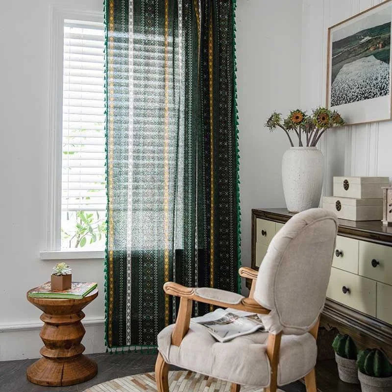 Rideau vert à motifs ethniques dans un salon lumineux. Ce rideau ajoute une touche colorée et chic à la décoration intérieure, s’intégrant parfaitement avec le fauteuil confortable et le buffet en bois à côté. Idéal pour les espaces accueillants et chaleureux, il filtre légèrement la lumière tout en préservant l'intimité. Un choix parfait pour relooker votre salon avec style.