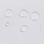 Gouttes d'eau sur une surface claire illustrant l'efficacité hydrophobe d'un produit innovant. Cette image montre la capacité de repousser les liquides, idéal pour ceux cherchant une solution aux éclaboussures.