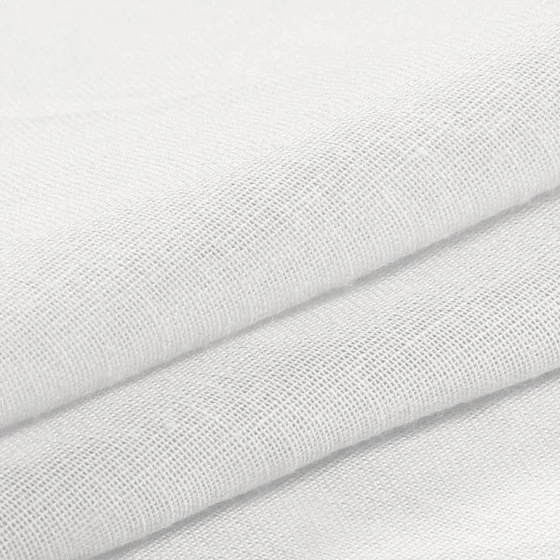 Tissu blanc plié soigneusement, idéal pour la confection de vêtements, accessoires ou décorations textiles. Le relief du tissage est bien visible, offrant une texture élégante pour une variété d'utilisations créatives.