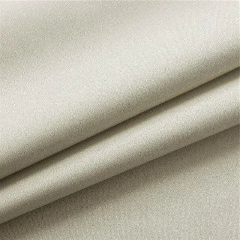 Tissu beige plié, idéal pour la couture et les projets textiles, offrant une apparence élégante et un design raffiné pour des créations personnalisées.