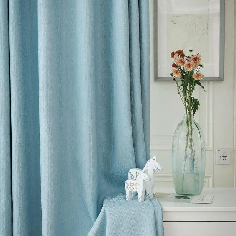 Rideaux bleu doux pour décoration intérieure, idéal pour votre salon ou chambre. Apportez une touche d'élégance avec ces rideaux élégants, complétés par un vase élégant contenant des fleurs fraîchement coupées. Transformez votre espace de vie avec style et sophistication.