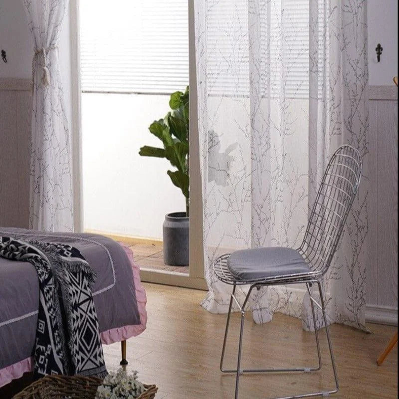 Chambre élégante avec chaise design, décorée de rideaux à motifs et plante d'intérieur, offrant une ambiance moderne et apaisante. Idéale pour aménager un espace de détente à la maison.