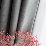 Rideaux gris élégants avec motifs délicats, mis en valeur par des fleurs roses pour une décoration d'intérieur raffinée et chaleureuse. Idéal pour ajouter une touche de sophistication à votre salon ou chambre.
