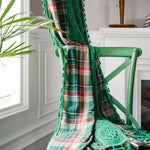 Écharpe verte à motif écossais élégamment drapée sur une chaise verte, ornée de détails en dentelle. Idéale pour apporter une touche de sophistication et de confort à votre tenue. Parfaite pour un style à la fois classique et moderne, ajoutant une note de couleur à votre garde-robe automnale et hivernale.
