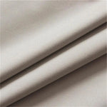 Tissu beige plié en plusieurs couches, idéal pour la confection de vêtements ou articles de décoration intérieure. Texture douce et élégante convenant à divers projets de couture.