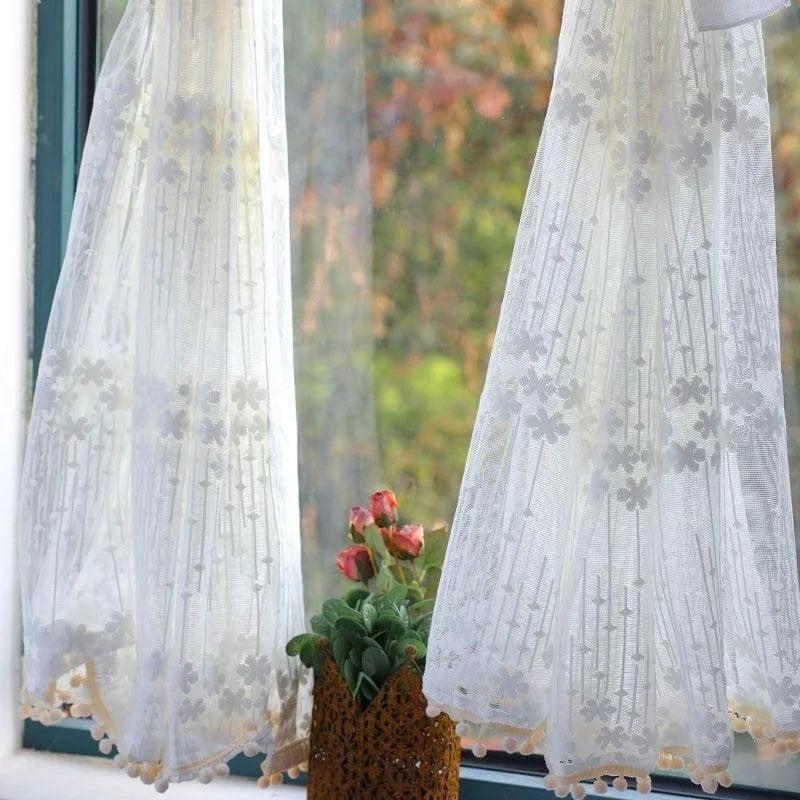 Rideaux blancs élégants avec motifs floraux suspendus devant une fenêtre, filtrant la lumière naturelle. Décoration intérieure lumineuse et raffinée, apportant une touche de sophistication à votre maison. Parfait pour chambre ou salon, ces rideaux floraux ajoutent une ambiance douce et accueillante.